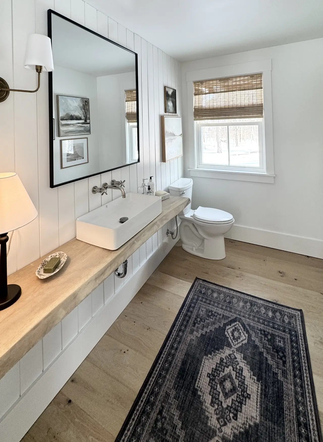 A double-vanity bath with a live-edge wood counter and vintage rug